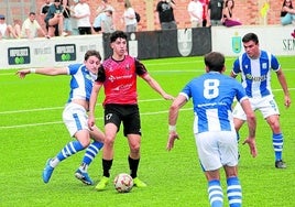 Un jugador del Cortes lleva el balón presionado por tres futbolistas del Beasain.