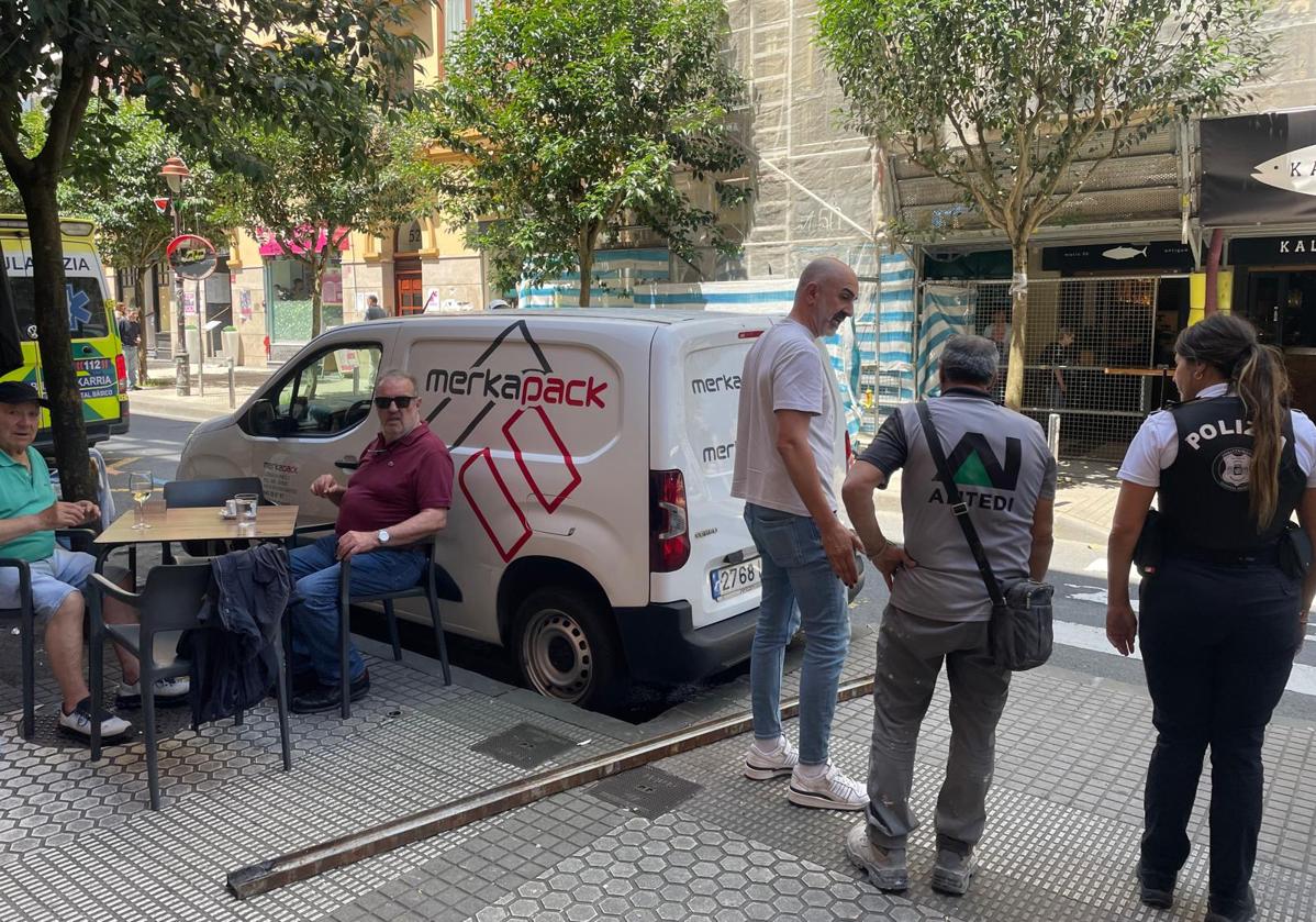 Varios clientes observan la barra metálica caída sobre la acera en la calle Matia de Donostia y que ha golpeado a un hombre.