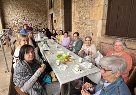 Participantes de Julita, Mairi y la Escuela de Empoderamiento en la mesa situada en los pórticos del ayuntamiento.