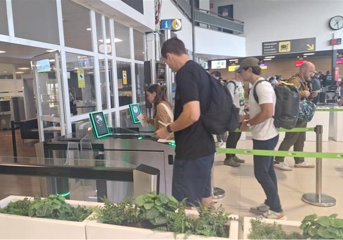 Varios pasajeros pasan sus tarjetas de embarque por el nuevo lector de Hondarribia.