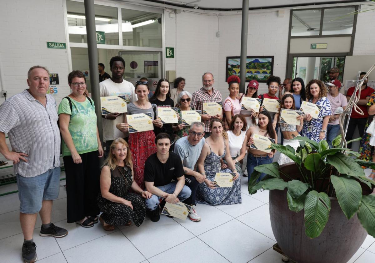 Los estudiantes posando con sus diplomas y profesores.