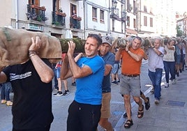 Un grupo de concejales, la alcaldesa y voluntarios portando el chopo hasta la Plaza.