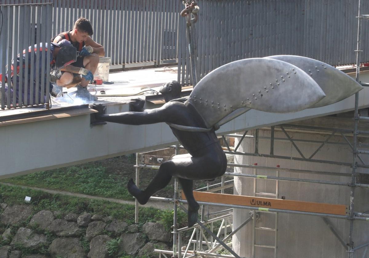 Dos operarios trabajan en la recolocación de la escultura, ayer.