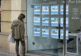 Una mujer frente al escaparate de una inmobiliaria en Gipuzkoa.