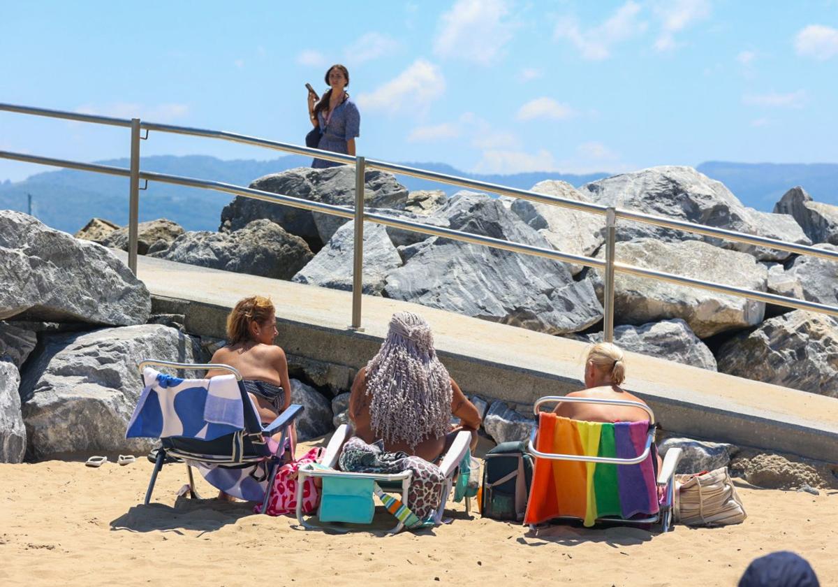 Tres mujeres toman el sol en la playa de Hondarribia este sábado, en el arranque de la ola de calor.