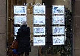 Un joven mira la oferta de pisos en una inmobiliaria en San Sebastián.