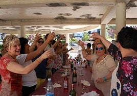 Vecinas en pleno brindis durante una de las formidables comidas de años anteriores.