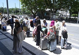 Un grupo de turistas espera en la parada de taxis junto a la estación de tren de Donostia.