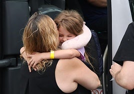 Una de las menores ucranianas al bajarse del autobús donde le esperaba su familia de acogida.