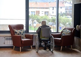 Una usuaria de una residencia de mayores en Usurbil, sentada en su silla de ruedas en la sala de estar.