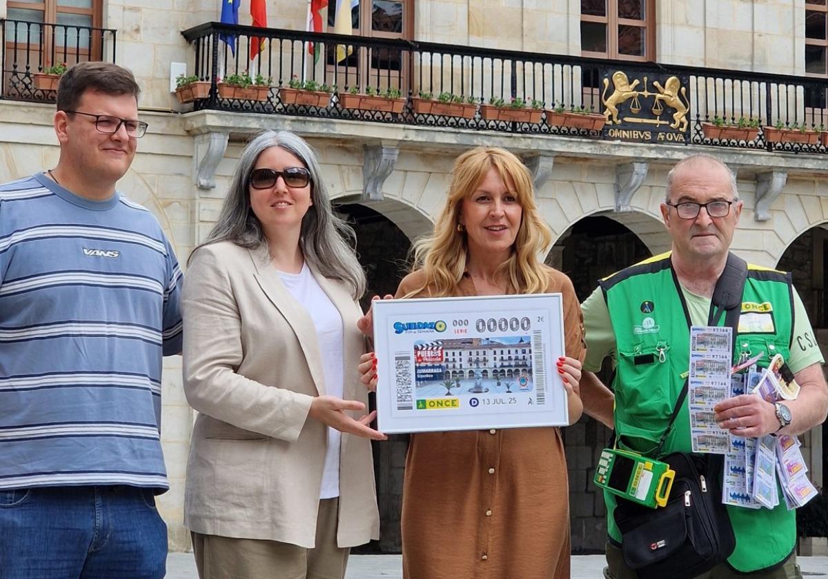 La delegada de ONCE Euskadi Usue Vallejo y la alcaldesa en funciones de Zumarraga Nerea Errasti sostienen la imagen del cupón del domingo.