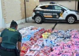 Un agente de la Guardia Civil con parte de las camisetas intervenidas.