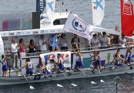 La patrona de ArraunLagunak, Joana Halsouet, ondea la bandera este domingo en Zierbena.