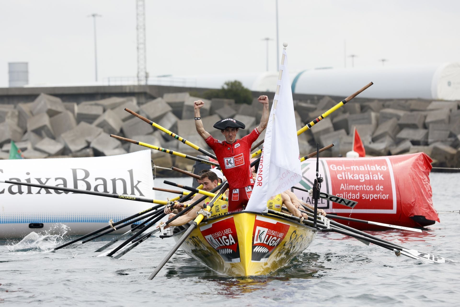 Gorka Aranberri celebra con los puños en alto y la bandera en el bote la victoria este domingo en Zierbena.
