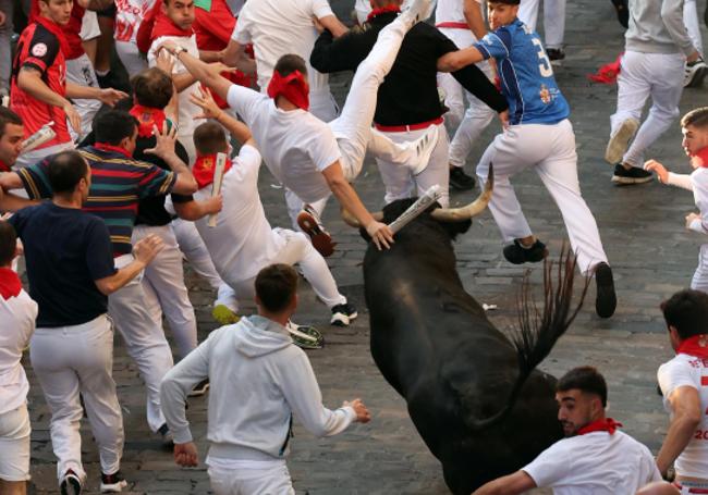 Momento captado desde atrás cuando el toro lanza por los aires a un corredor en Santo Domingo.