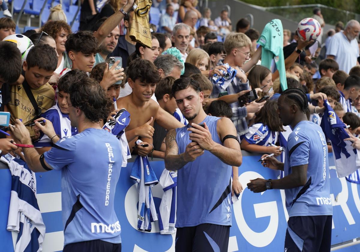Odriozola, Javi López y Becker atienden las peticiones de autógrafos y fotos de los realzales que han acudido este lunes a Zubieta.