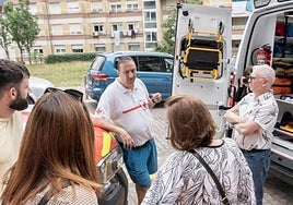 Amaya Goyaran entregando al viudo de Patricia Puente un obsequio, y un grupo en las puertas abiertas.
