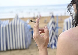 Una mujer fuma un cigarro en la playa de Zarautz.