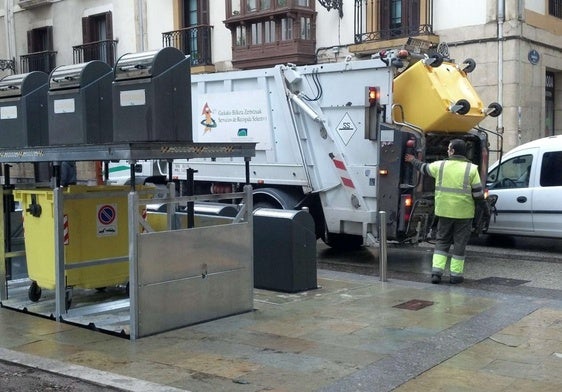 Un trabajador del servicio de recogida de residuos opera el camión en los contenedores soterrados de la calle Narrika.