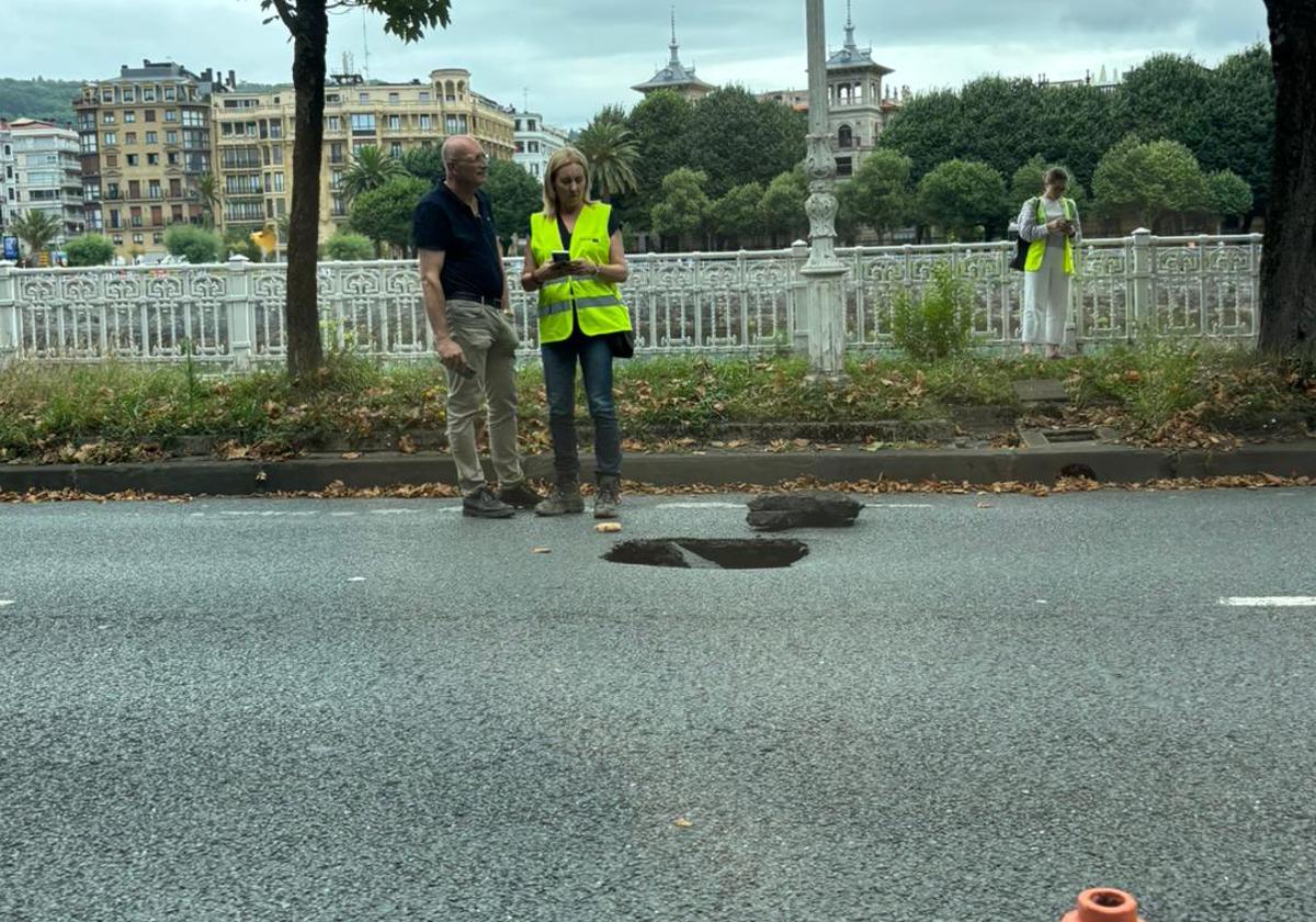 Tecnicos y afectados al lado del socavón que se ha abierto en el paseo de los Fueros de San Sebastián.
