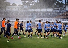 Los jugadores de la Real calientan en los primeros minutos del entrenamiento de ayer.