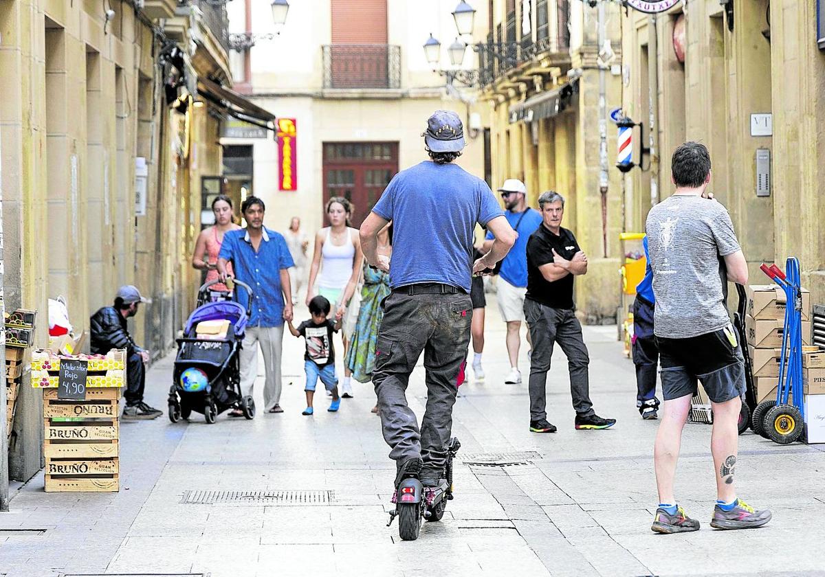 Un hombre circula sobre un patinete eléctrico por la Parte Vieja de Donostia.