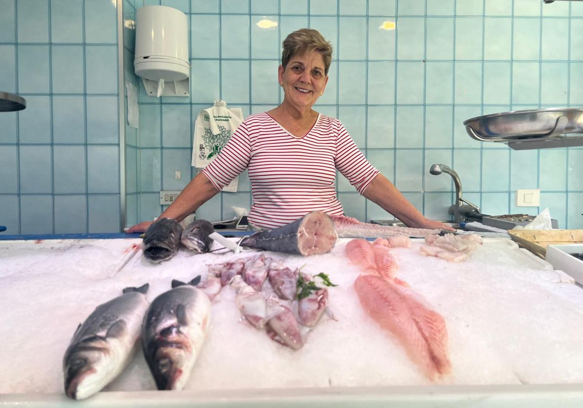 Maite tras el escaparate de la pescadería, desde la que ha fraguado una gran relación con los vecinos.
