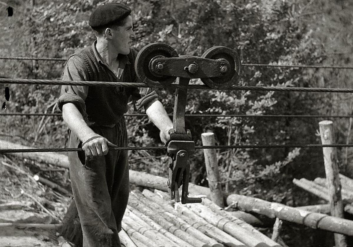 Operario trabajando en el cable de Belkoain, en Andoain, con descargadero en el antiguo caserío Bazkardo. Poleas como la de la imagen se hacían en la fábrica Azpeitia Hnos. de Beasain.