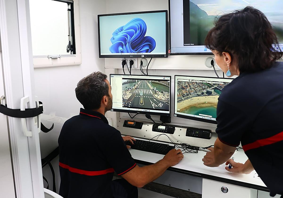 Dos agentes visualizan pantallas dentro del recién estrenado vehículo de la UCOP durante el Jazzaldia.