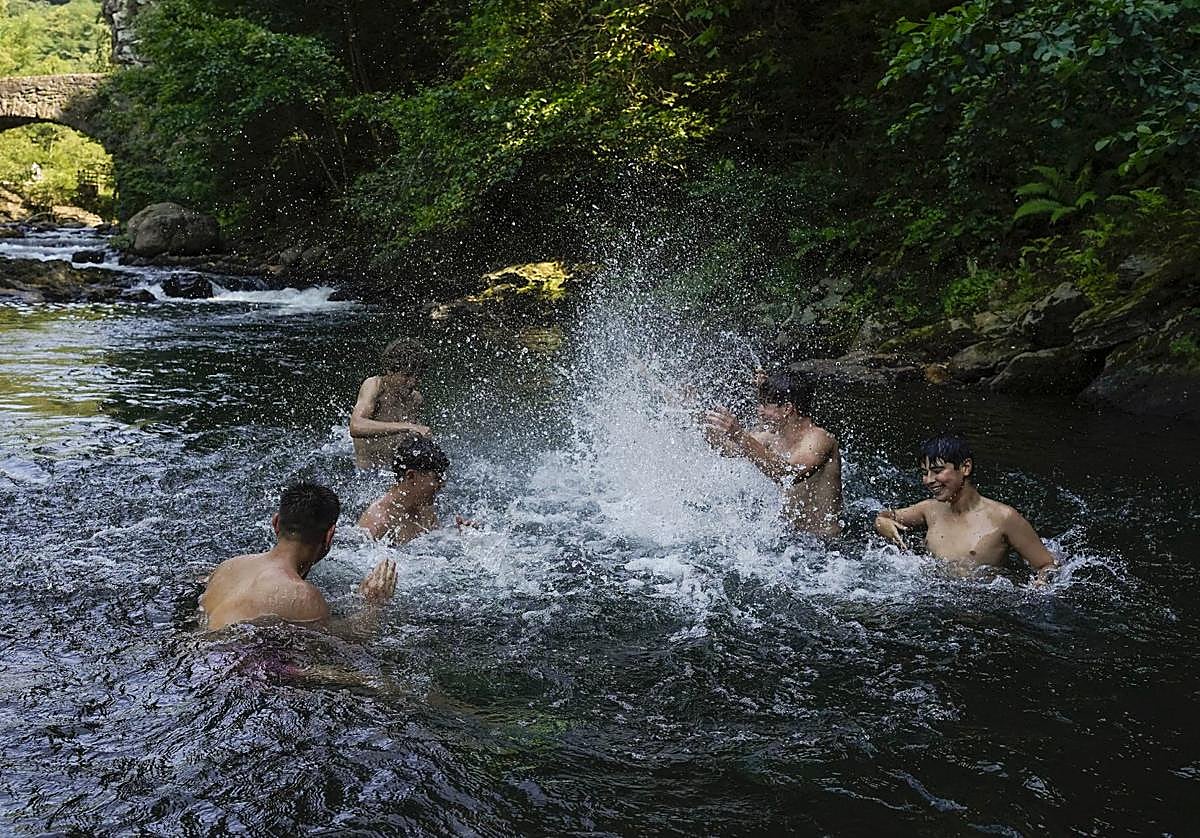 Varios jóvenes se refrescan en Andoain ante el fuerte calor de este lunes.