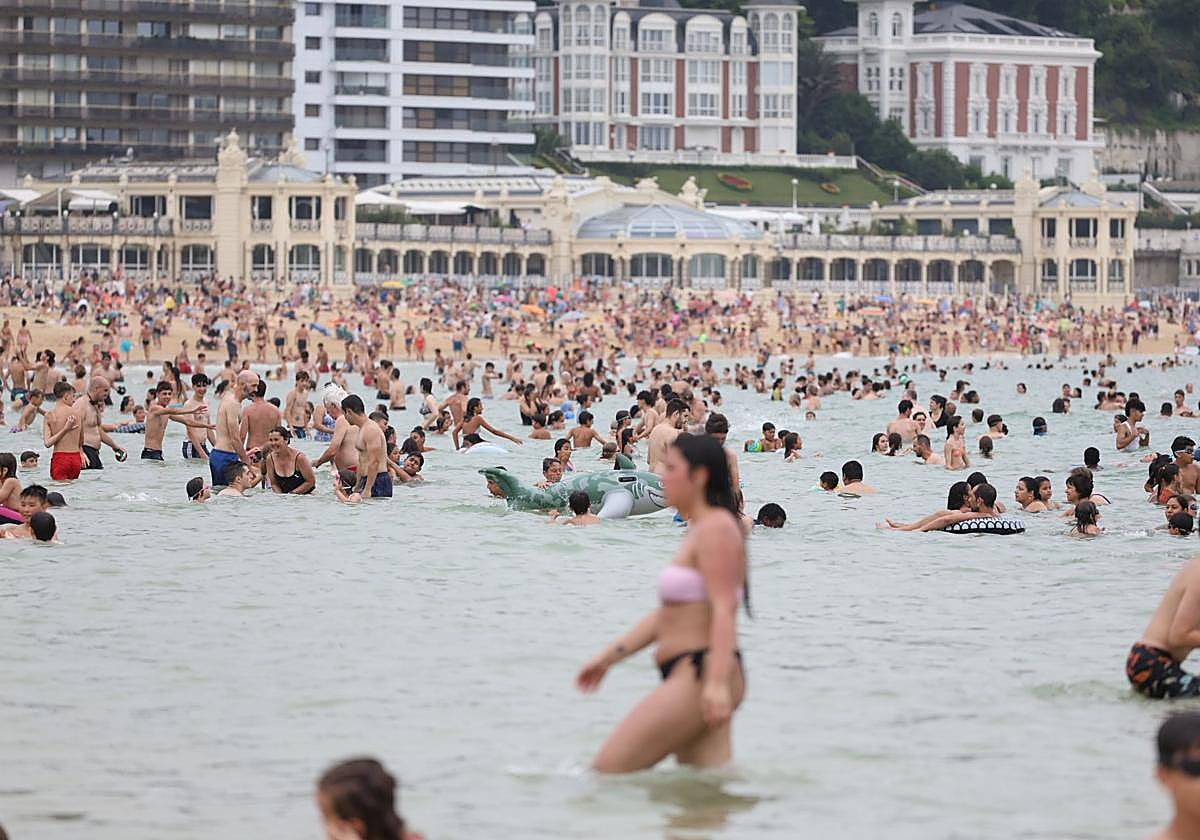 Varias personas se bañan en la playa de La Concha, en Donostia