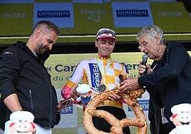 Markel Beloki sostiene un gigante pretzel en el podio del Tour de Alsacia.