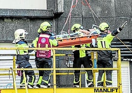 Bomberos socorren a un operario herido en una obra.