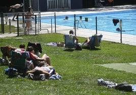 Varias personas toman el sol y se refrescan en la piscina de Urretxu.