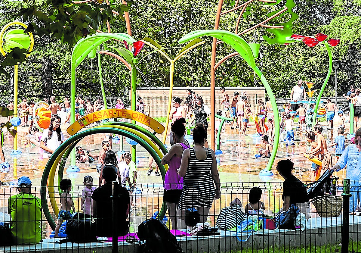 Decenas de personas juegan bajo el agua en el parque 'Atsobakar', en Lasarte-Oria.