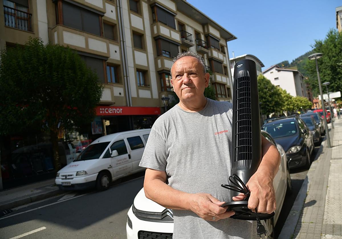 Francisco Lozada sujeta un ventilador frente a su tienda en Urretxu.