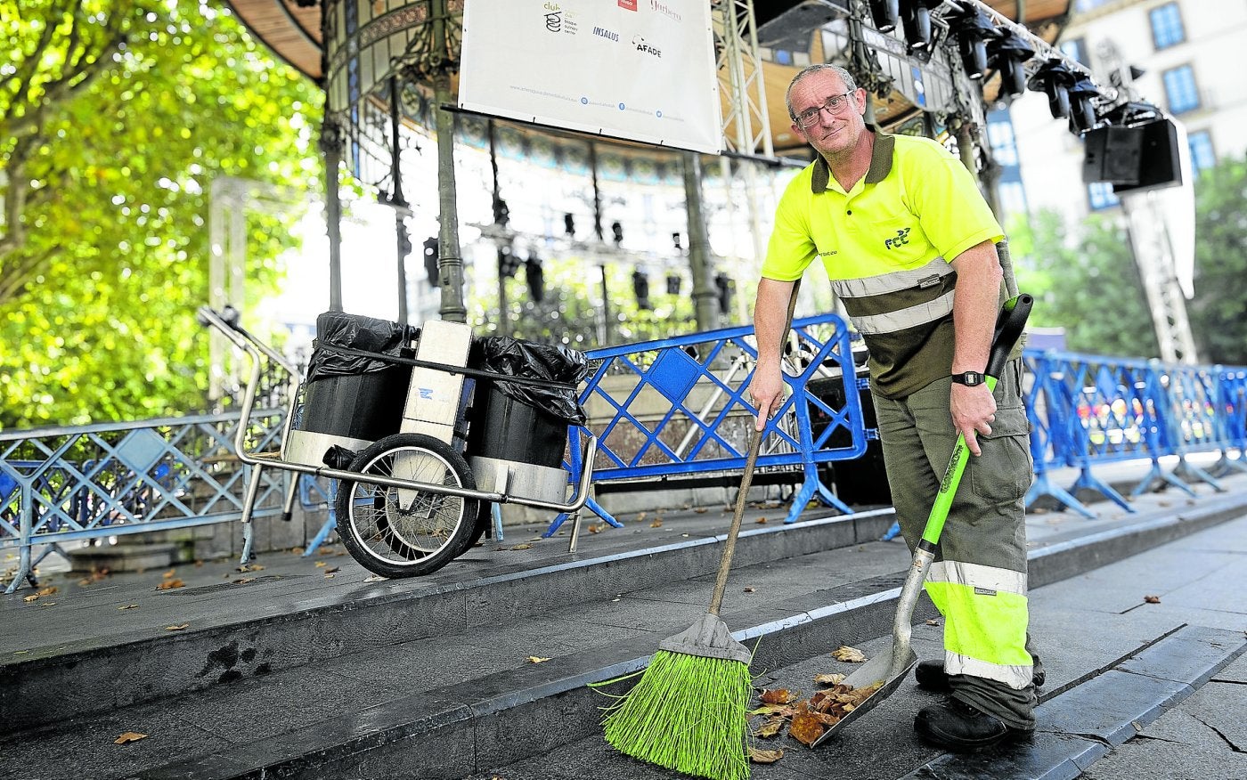 Lorenzo Barrada, barrendero, su carro y su escoba con los que limpia las calles de Donostia.