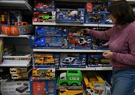 Una empleada selecciona un producto en una juguetería de San Sebastián.