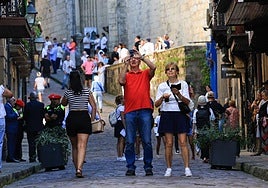 Dos turistas sacan fotos en la calle Mayor de Hondarribia.