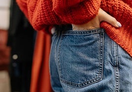 Una joven con las manos metidas en los bolsillos del pantalón.