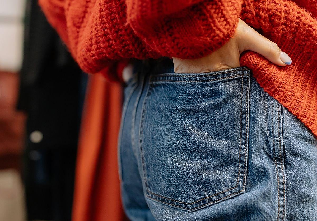Una joven con las manos metidas en los bolsillos del pantalón.