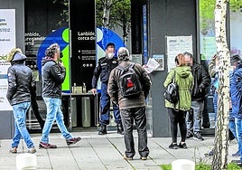 Un grupo de personas hace cola para acceder a una oficina de Lanbide.