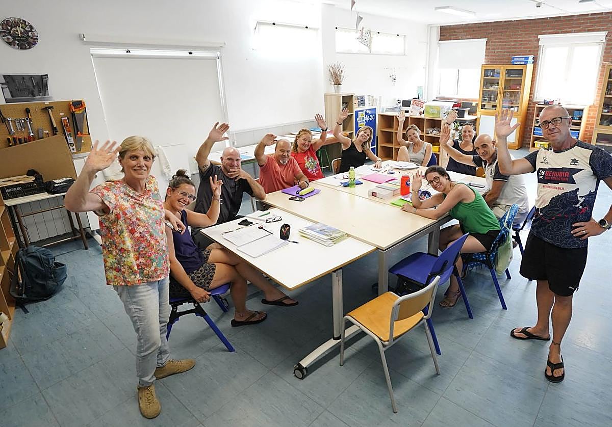 Los nueve alumnos del barnetegi familiar saludan sentados, con sus profesores Elena y Juanmi de pie, en la eskola txikia de Aduna