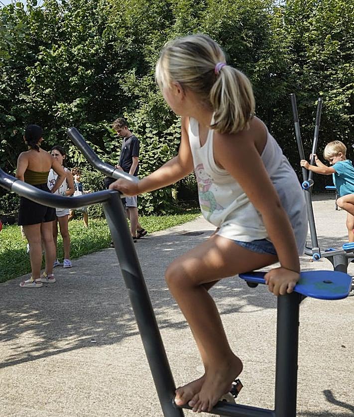 Imagen secundaria 2 - Los niños y niñas disponen de un entorno natural privilegiado para jugar, junto a dos monitores, cuando sus padres están en clase y Oihane y Nekane atienden en clase, con los apuntes sobre la mesa. 