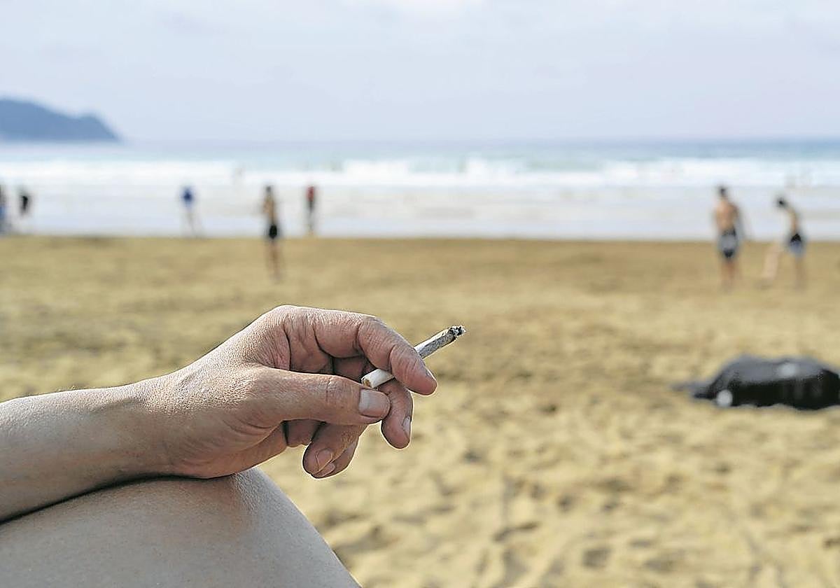 Una mujer fuma un cigarrillo en la playa de Zarautz.