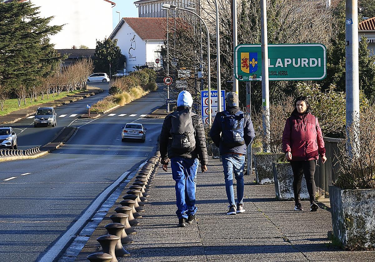 Dos migrantes cruzan el puente Santiago de Irun en dirección Hendaia.