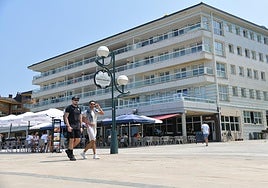 Varias personas caminan por el paseo marítimo de Zarautz, que alberga viviendas de un elevado precio.