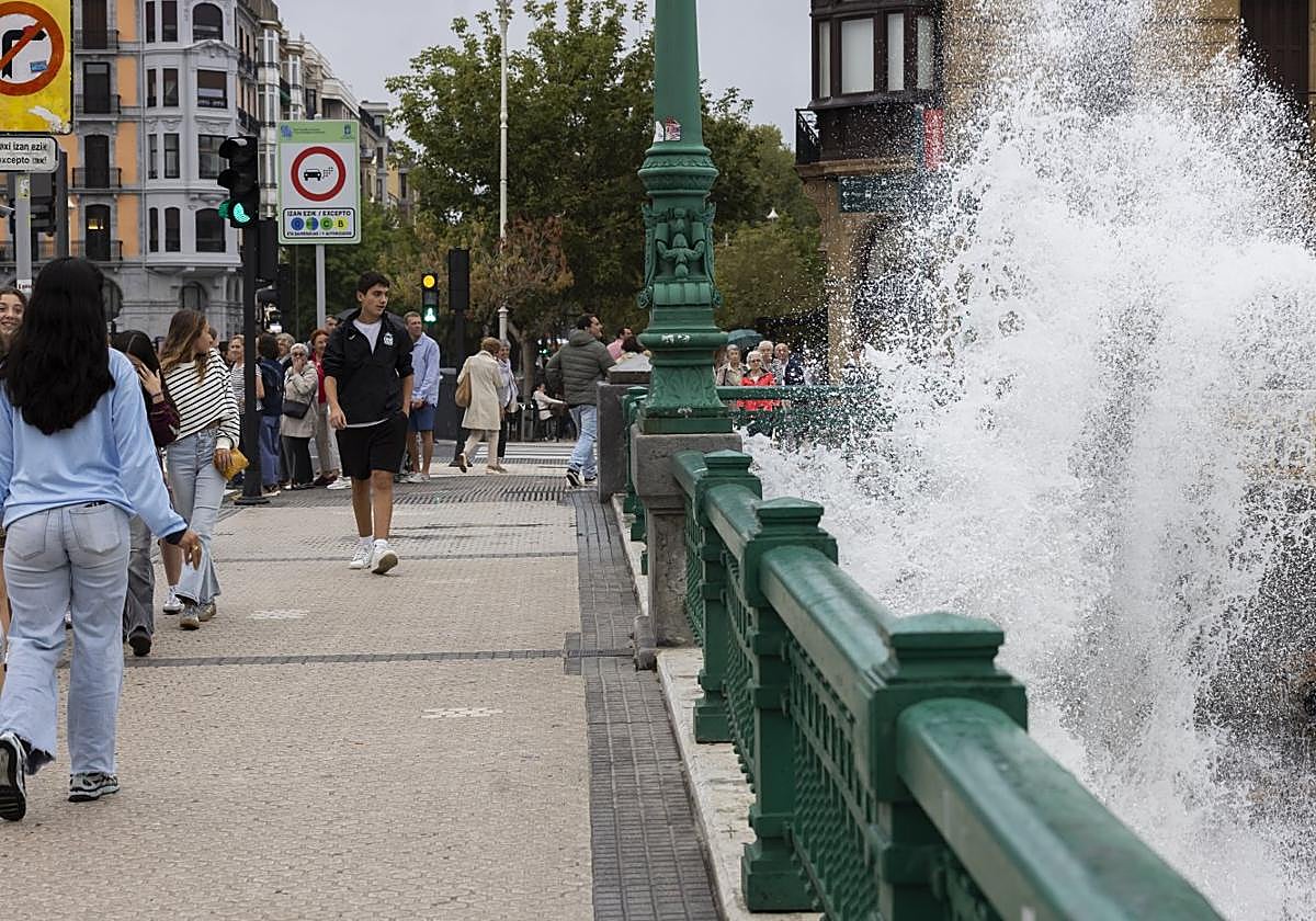 Una gran ola sobrepasa las barandillas en el puente de la Zurriola.