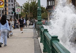Una gran ola sobrepasa las barandillas en el puente de la Zurriola.