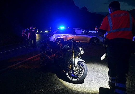 Un agente de la Ertzaintza fotografía la moto y el coche, claramente dañado en la parte derecha, afectados en el accidente en Deba.